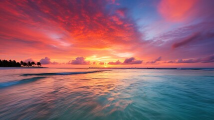 A dynamic snapshot of a brilliant beach sunset with the sun dipping into the ocean and colorful clouds