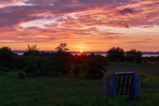 Ebeltoft / Denmark: Self-closing pasture gate in the sunset in the hilly Mols Bjerge National Park near Ebeltoft