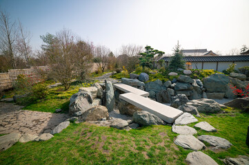 A kareike style dry pond in a Japanese garden in a public park. The stones are arranged to form a pond shape.