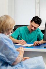 in a plastic surgery clinic a doctor consults an elderly woman making notes on paper