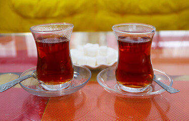 Closeup of a Pair of Hot Turkish Tea with Plate of Sugar Cubes in the Backdrop
