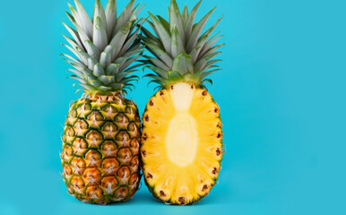 Two pineapples on a blue background. Beautiful ripe pineapple cut. Tropical fruits on a blue background. Pineapple close-up.
