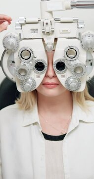 Optometry, eye exam and woman with machine in clinic for glasses, prescription lens and spectacles. Healthcare, optician consulting and patient in phoropter for eyesight, vision and medical service