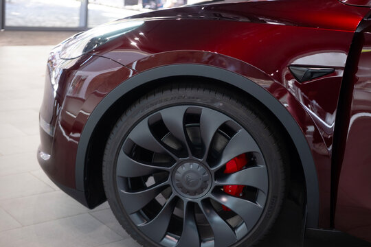 Tesla car model Y in cherry red color in Studio, electric vehicle in showroom, li-ion 4680 battery, alternative energy development concept, Elon Musk company, Frankfurt, Germany - September 2, 2023