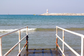 By the sea, inclined disabled ramp, with lighthouse