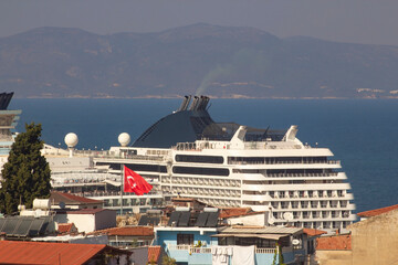 A view of the Large Cruise Ship Moored in the Port, with the Turkish Flag and Apartments