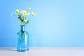 spring bouquet of daisies flowers over wooden table and blue background - 781307466