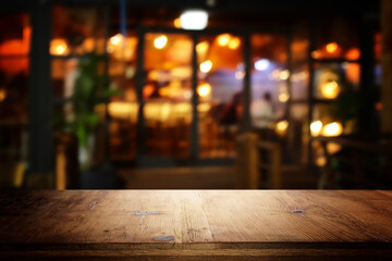 image of wooden table in front of abstract blurred background of restaurant lights - 781307671