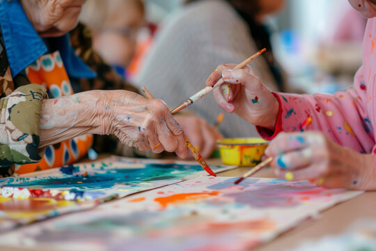 Art workshops in a bright studio space, where seniors collaborate with children on creative projects