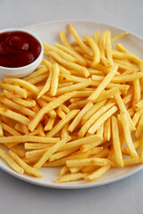 Fried French Fries with Ketchup on a Plate, side view.