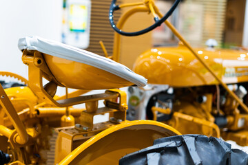 Small yellow tractor in exhibition, closeup details, wheels