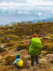 Family travel in Norway - mother and child hiking in Lofoten islands mountains adventure healthy lifestyle outdoor, parent and kid climbing together active vacations with backpack