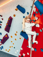 Child training on children climbing wall playground indoor, 4 years old girl playing in kindergarten sports activity for kids