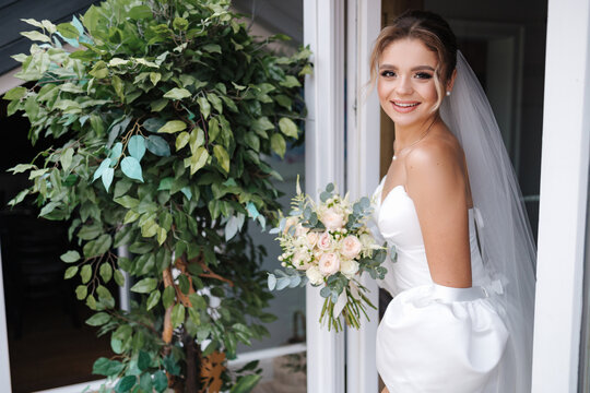 Gorgeous bride in beautiful wedding dress hold flowers in hands and waiting for groom