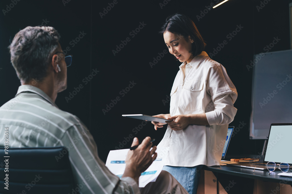 Poster asian female using application on digital tablet during briefing working process with colleague for 