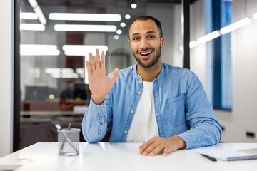 Indian man in office having a video call and smiling