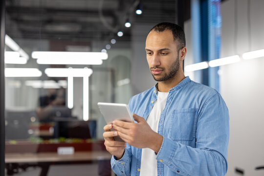 Indian businessman using tablet in modern office setting