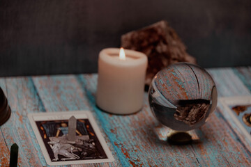 A tarot card reading session depicted with candles, crystals, and mystical accessories on a rustic...