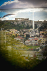Obraz premium Stunning view of Acropolis and vibrant buildings under clear blue sky, captured on a sunny day in Athens