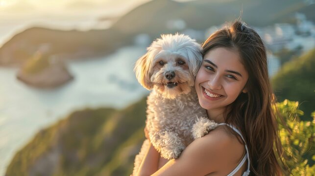 Beautiful smile of tourist  young woman. she's traveling with dog. they are best friend.  she's holding a dog at view point at sea and mountain view background. morning light pet day concept