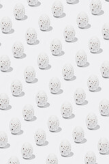 Pattern of  white Easter egg casting shadow on white background, minimalism concept
