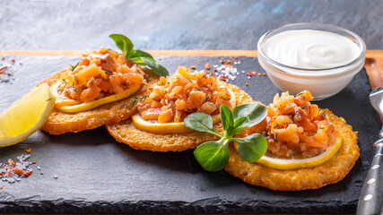 Potato pancakes with salted salmon and sour cream.