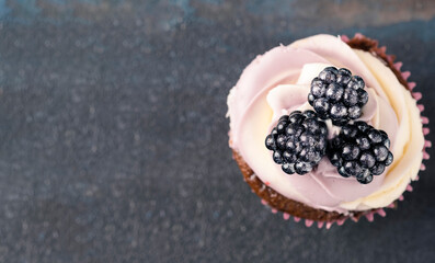 Сupcake with blackberry. Top view, copy space
