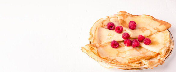 Tasty pancakes with fresh raspberry on a plate. White background. Copy space