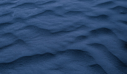 blue desert sand shaped into waves by the wind