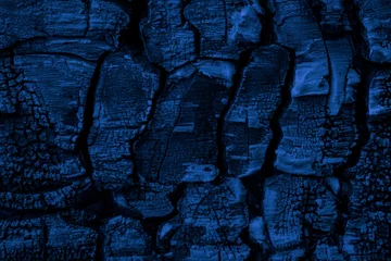 Foto auf Glas blue charred board, cracked charcoal structure © Remigiusz