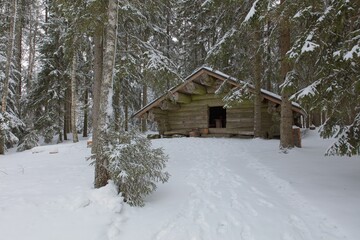 View of Idänpääkallio wooden shelter at Torronsuo National Park in cloudy winter weather, Tammela, Finland.