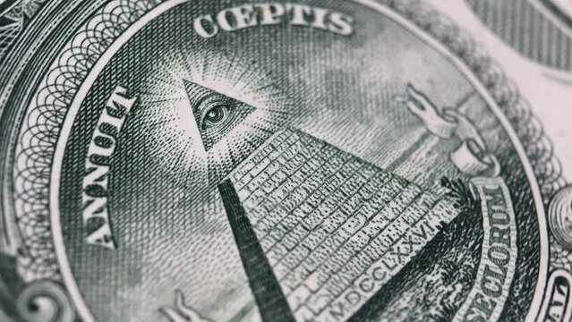 Macro view of the Great Seal's Eye of Providence on a US dollar bill, a design often associated with mystery and the Illuminati.