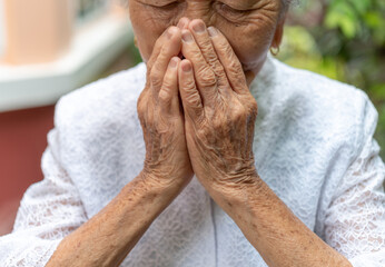 Senior Asian women use to hands to closing her mouth  unwell coughing with sore throat...