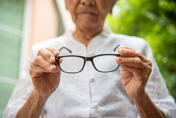 Senior Asian woman holding  eyeglasses,  eye sight problem, optometry optics ophthalmology, bad...