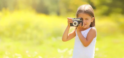Foto op Canvas Child with film camera taking picture outdoors on sunny summer day © rohappy
