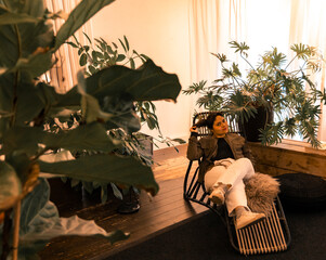 Woman relaxing at a bohemian home apartment surrounded with a houseplants.