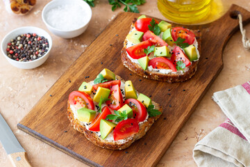 Toast with white cheese, tomatoes and avocado. Healthy eating. Vegetarian food.