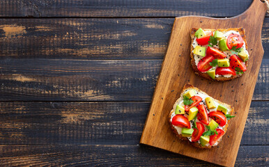 Toast with white cheese, tomatoes and avocado. Healthy eating. Vegetarian food.