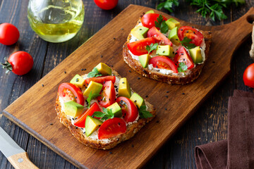 Toast with white cheese, tomatoes and avocado. Healthy eating. Vegetarian food.