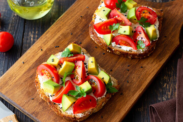 Toast with white cheese, tomatoes and avocado. Healthy eating. Vegetarian food.