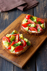 Toast with white cheese, tomatoes and avocado. Healthy eating. Vegetarian food.