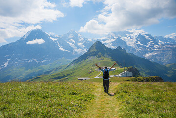 enthusiastic hiker with arms outstretched on Mannlichen mountain trail, swiss alps - 781349058