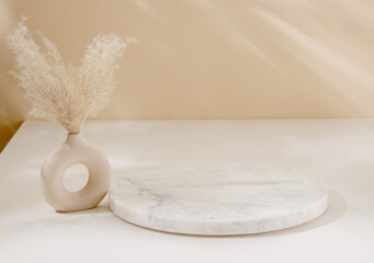 Marble podium with beautiful sunlight shadows with vase and pampas grass. Luxury aesthetic background for design and product presentation