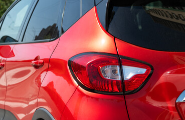 Closeup of rear light on red car captur parked in the street. selective focus