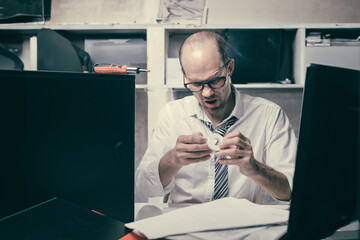 Portrait of sad nervous office manager using adhesive tape after injury, Male attempting computer mending at the workplace looks anxious and disheartened