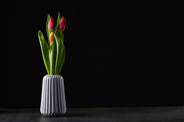 boquet of tulip on a black background standing in a vase