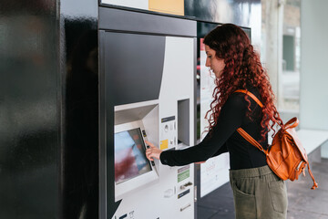 Tourist buys a tram ticket at a ticket machine in a city