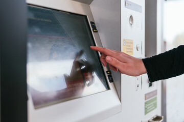 Detail of a woman's hand typing on a ticket sales touch screen