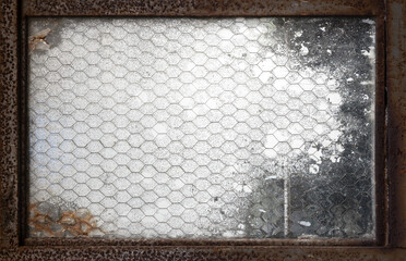 finestra con rete metallica arrugginita sporca trasparente - obrazy, fototapety, plakaty