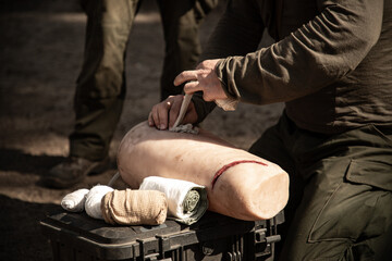 man applying medical  bandage on the dummy leg 